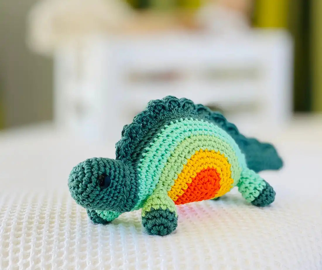 Fairtrade knit rainbow stegosaurus toy