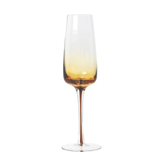 Celebrate with your favourite bottle of bubbles in these beautiful amber champagne glasses from the Danish brand, Broste Copenhagen.  This glass has a rich golden colour, inspired by amber, which makes the glass shine in warm honey tones.  Dimensions: 7cm diameter x 23cm high  Volume: 200mls